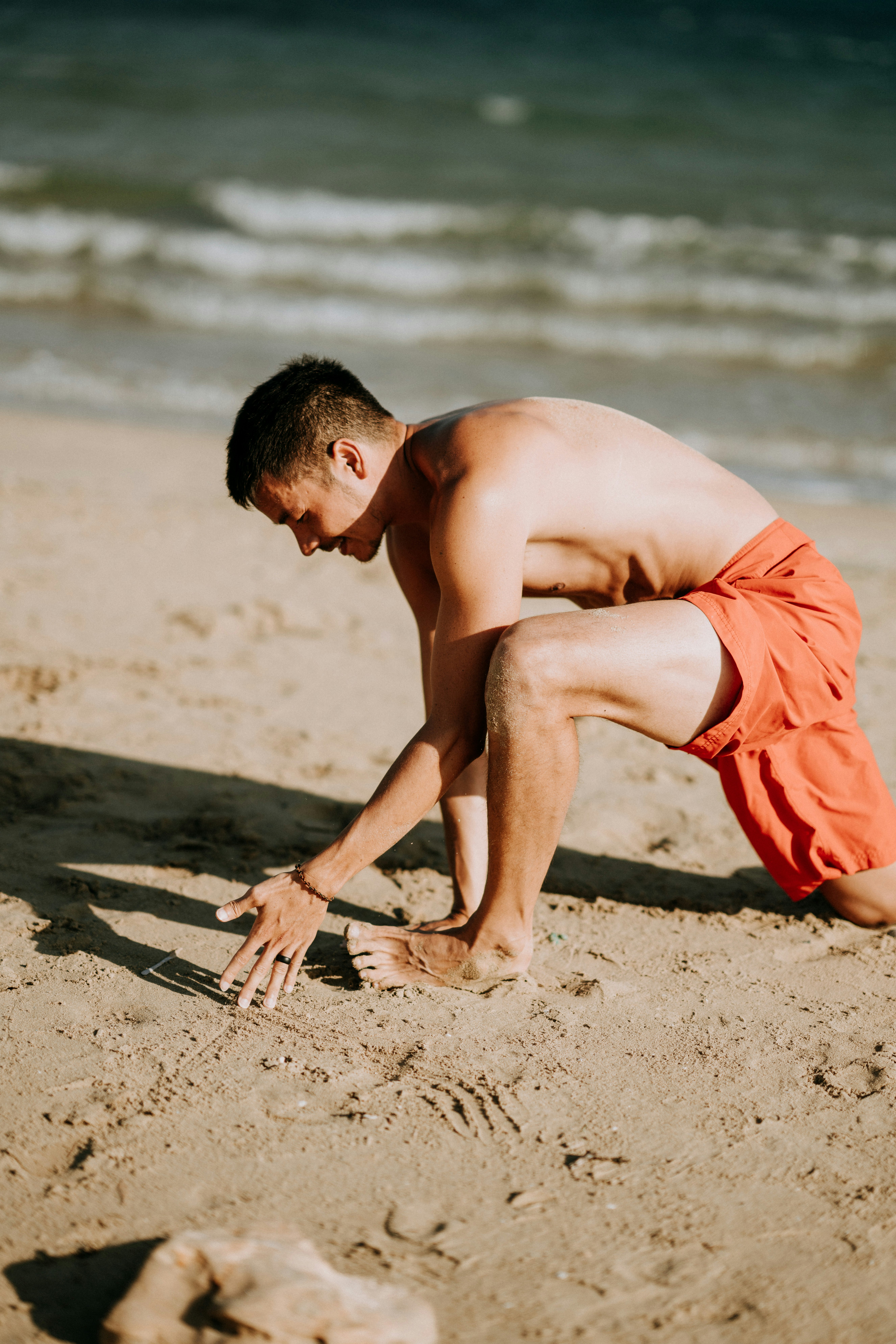 man kneeling holding the sand